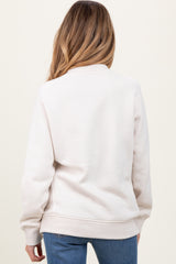 woman wearing a light beige maternity sweatshirt with a cozy fit, viewed from the back