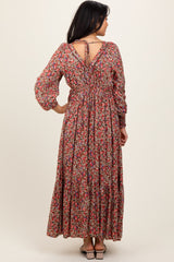 woman wearing a floral long sleeve maxi dress with a smocked back and tie detail, viewed from the back