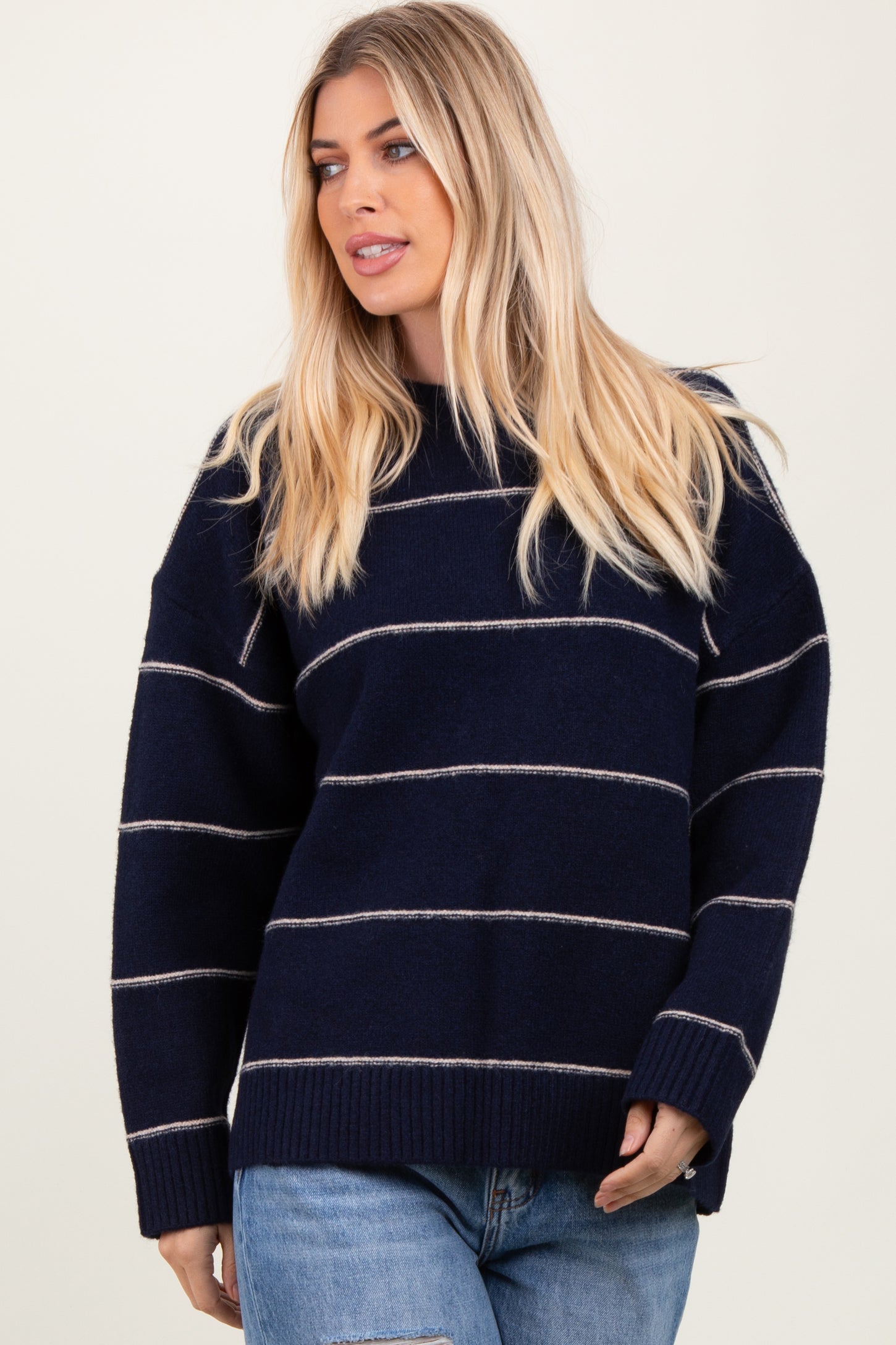 woman wearing a navy blue striped oversized sweater with a relaxed fit and long sleeves