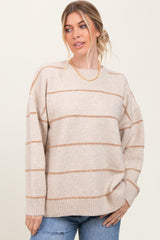 woman wearing a beige oversized sweater with rust-colored stripes and relaxed fit, styled with casual jeans