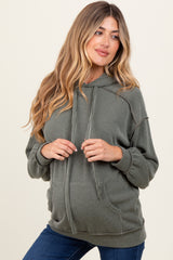 woman wearing a green ribbed hoodie and showing her baby bump