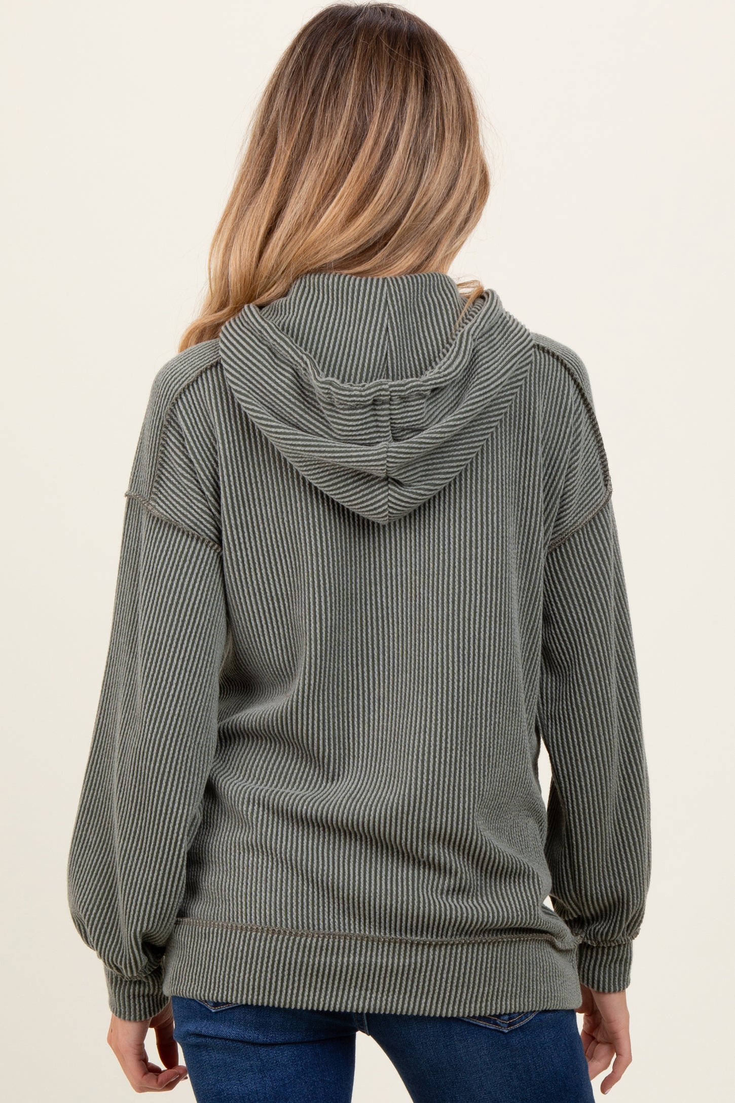 woman wearing a green ribbed hooded maternity sweatshirt, showing the back view with a relaxed fit