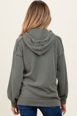 woman wearing a green ribbed hooded maternity sweatshirt, showing the back view with a relaxed fit