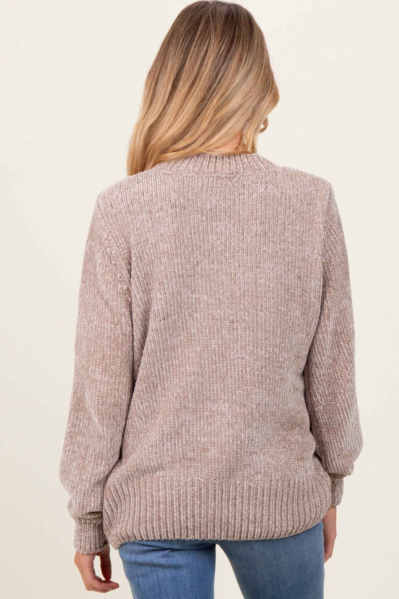 woman wearing a soft beige long sleeve maternity sweater with ribbed texture, seen from the back