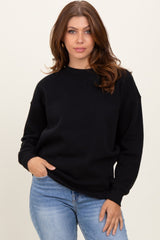 woman wearing a black oversized sweatshirt with a relaxed fit and light blue jeans