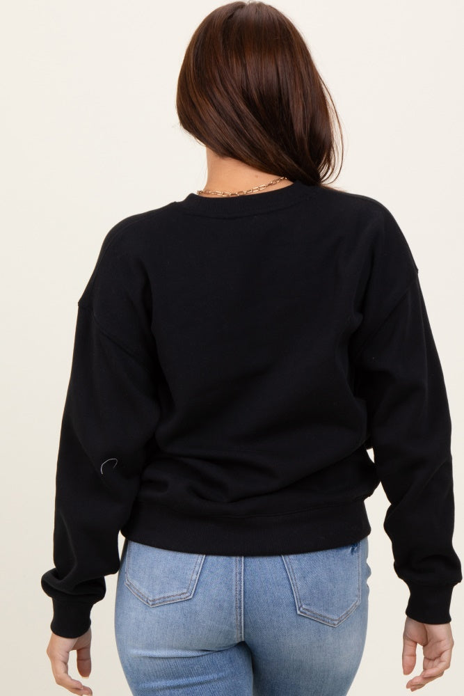 woman wearing a black oversized sweatshirt from the back with long sleeves and a relaxed fit paired with light blue jeans