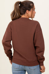 woman wearing a brown maternity sweatshirt, showing the back view with relaxed fit and long sleeves