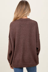 woman wearing a brown oversized maternity sweater, view from the back