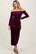 woman wearing a long sleeve off-the-shoulder plum velvet dress with a fitted silhouette