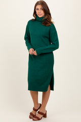 woman wearing a green turtleneck sweater dress with side slits and brown heeled sandals