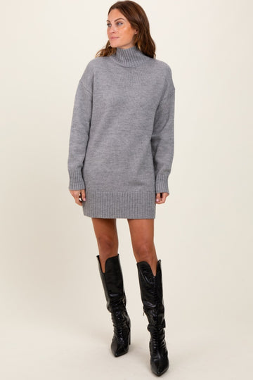 woman wearing a gray turtleneck sweater dress with ribbed cuffs and hem, paired with knee-high black boots