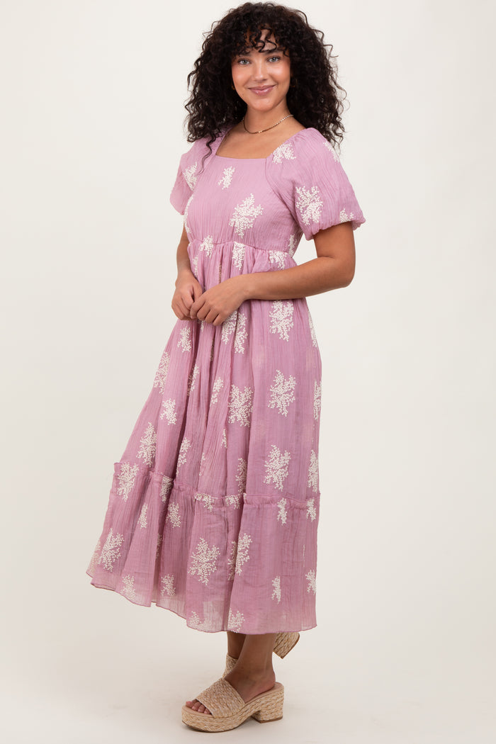woman wearing a pink floral midi dress with short sleeves and a tiered skirt, styled with woven espadrille wedges