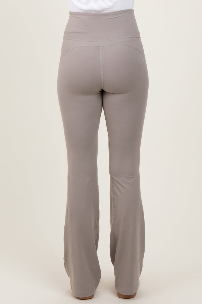 woman wearing high-waisted light brown flared leggings, view from the back