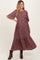 woman wearing a burgundy floral maternity dress with short sleeves and a tiered skirt, showing her baby bump