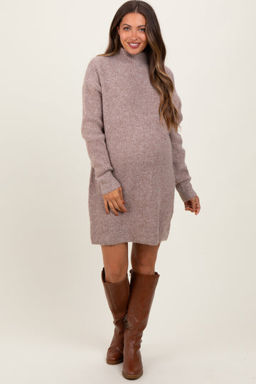 woman wearing a taupe maternity sweater dress with a mock neck and showing her baby bump, paired with brown knee-high boots