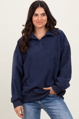 woman wearing a navy blue oversized fleece pullover with a collar and long sleeves, styled with light blue jeans