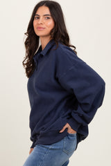 woman wearing a navy blue oversized fleece pullover with a collar and relaxed fit