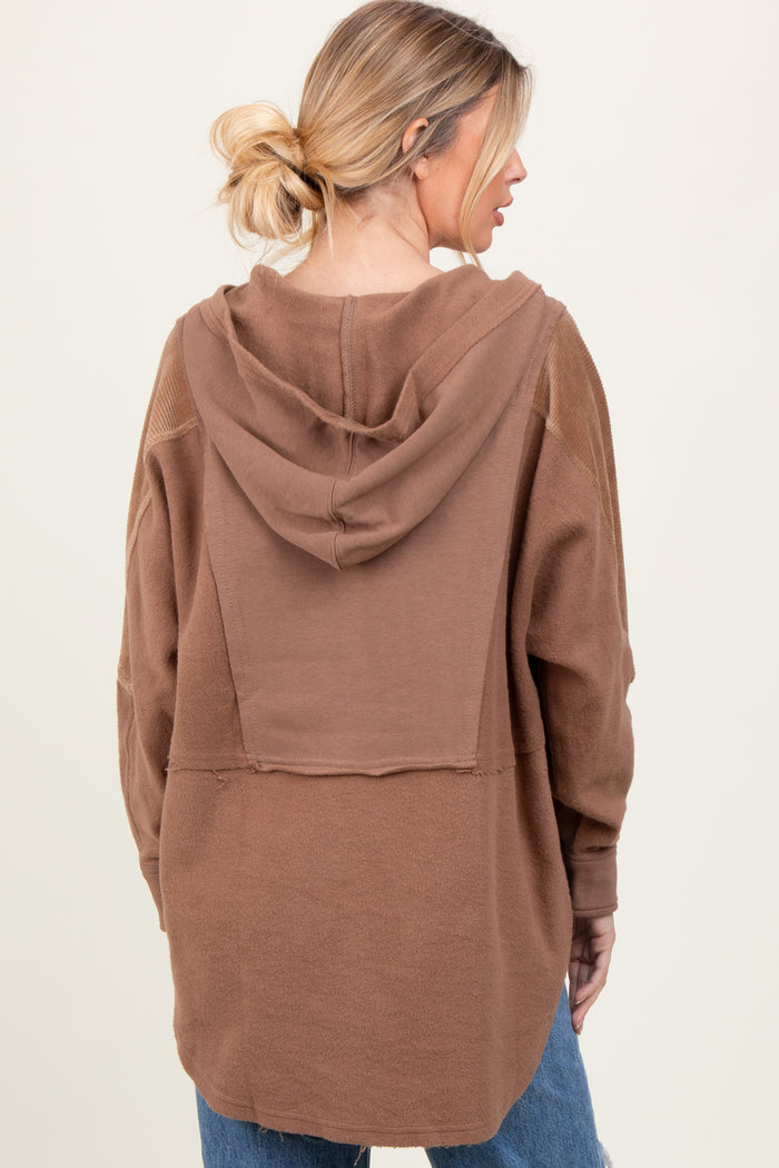 woman wearing a brown oversized hoodie with a back view, featuring a hood and relaxed fit