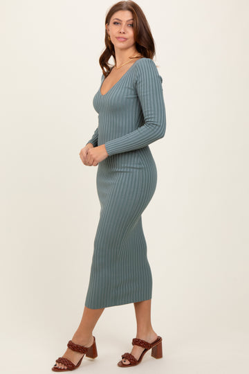 woman wearing a teal ribbed long sleeve midi dress and brown heeled sandals, posing sideways