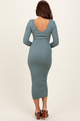 woman wearing a teal ribbed long sleeve midi dress with a low back and fitted silhouette