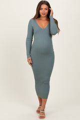 woman wearing a green ribbed long sleeve maternity dress and showing her baby bump