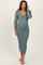 woman wearing a green ribbed long sleeve maternity dress and showing her baby bump