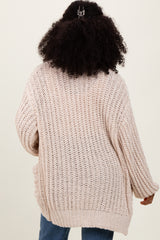 woman wearing a soft pink oversized knitted cardigan, styled with a relaxed fit and ribbed cuffs