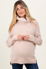 woman wearing a light pink maternity turtleneck sweater with a relaxed fit and visible baby bump