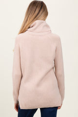 woman wearing a soft pink maternity sweater with a cowl neck and ribbed texture, view from the back