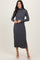 woman wearing a dark grey long sleeve turtleneck midi dress with textured pattern and side slit