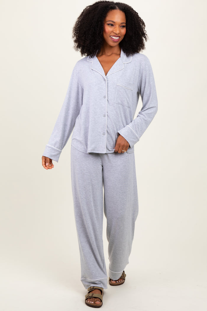 woman wearing a gray pajama set with a button-up shirt and loose pants, walking and smiling