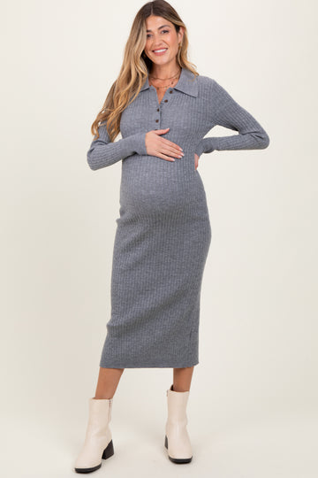 woman wearing a grey ribbed midi maternity dress with a collar and buttons, holding her baby bump