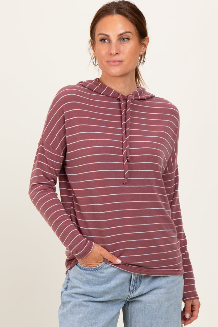 woman wearing a maroon and light gray striped hooded long sleeve sweatshirt with a relaxed fit and pockets