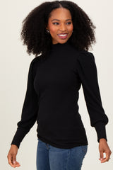 woman wearing a black ribbed mock neck long sleeve top with puff sleeves and smiling