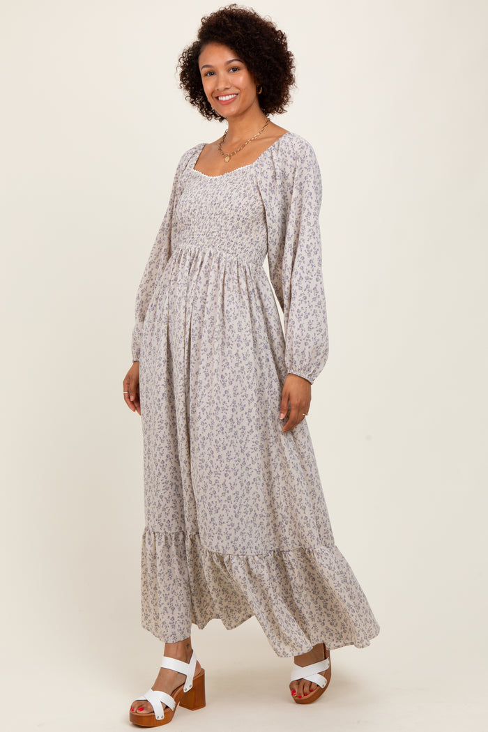 woman wearing a long floral maxi dress with long sleeves and a tiered skirt, posing and smiling