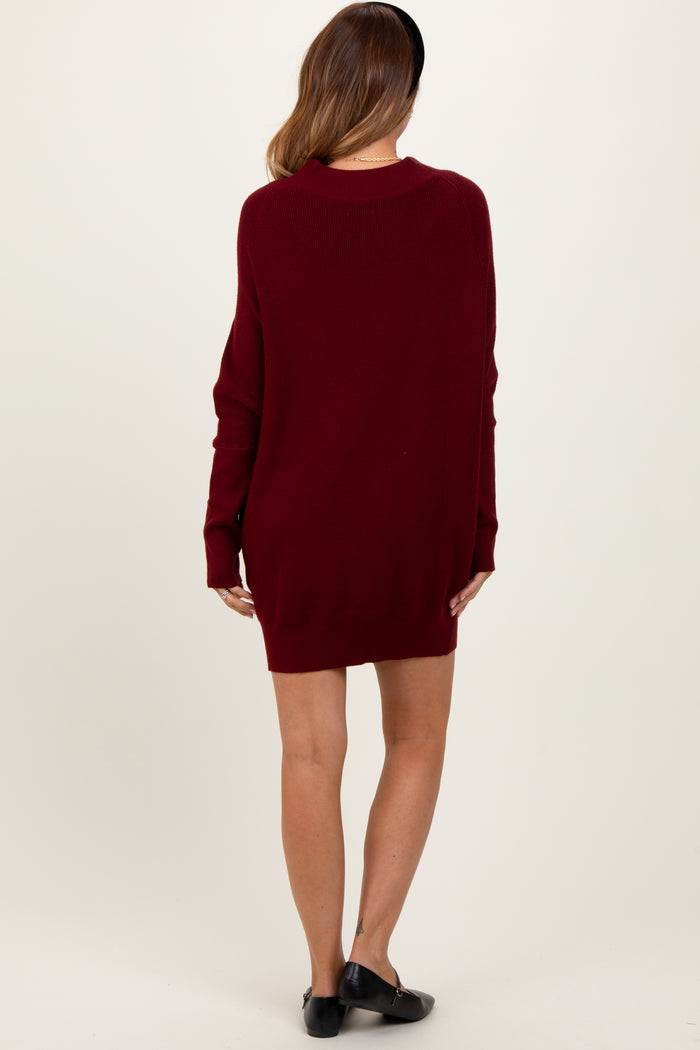 woman wearing a burgundy oversized sweater dress with long sleeves and a relaxed fit from the back