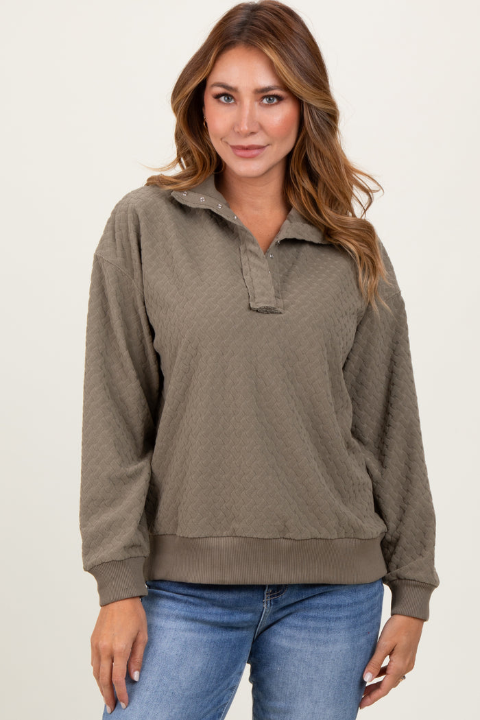 woman wearing a taupe quilted pullover sweater with a collar and long sleeves, paired with blue jeans