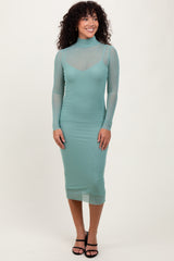 woman wearing a mint green long sleeve bodycon dress with sheer details and a mock neck design