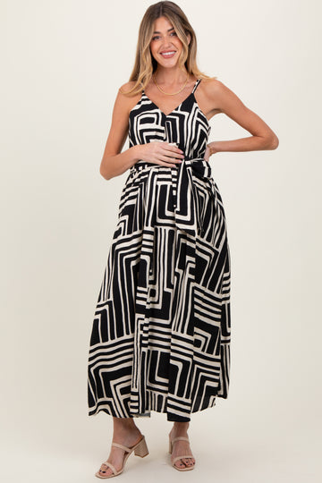 woman wearing a black and white patterned maternity maxi dress with a tie waist and visible baby bump