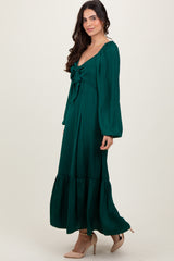 woman wearing a green maxi dress with a tie front and long sleeves, styled with beige heels
