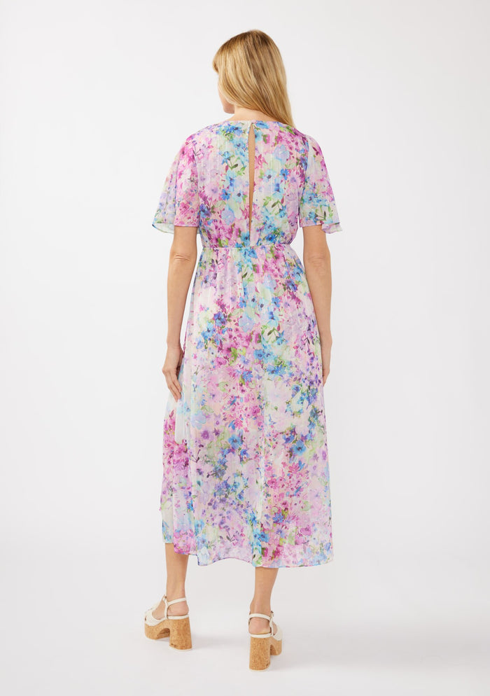 woman wearing a floral print maxi dress with short sleeves and a tie at the waist, showing a slight back opening