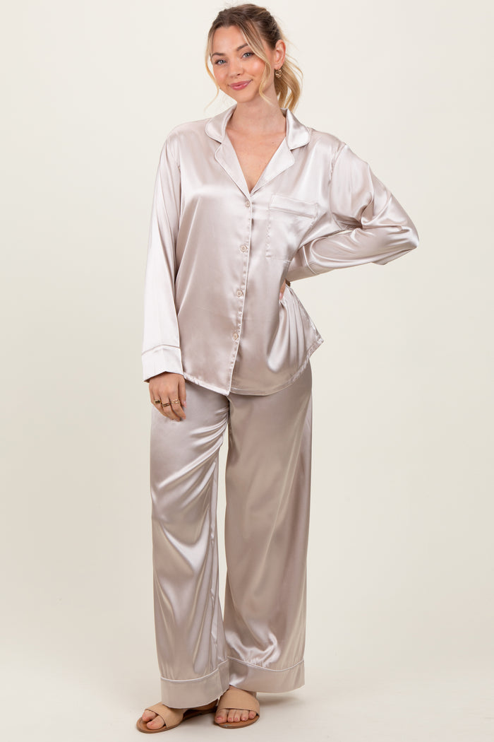 woman wearing a light beige satin pajama set with long sleeves and wide-leg pants