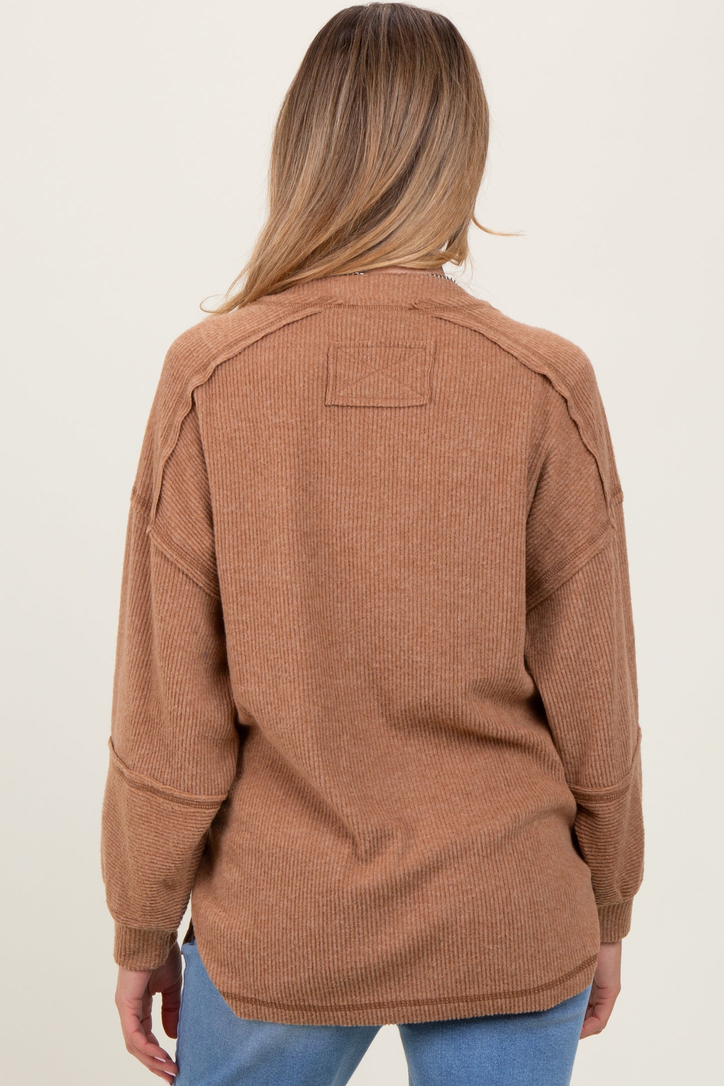 woman wearing a brown textured maternity sweater, showing the back view, with relaxed fit and long sleeves
