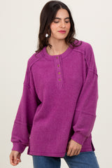 woman wearing a vibrant purple oversized button-up sweater with ribbed texture and dropped shoulders