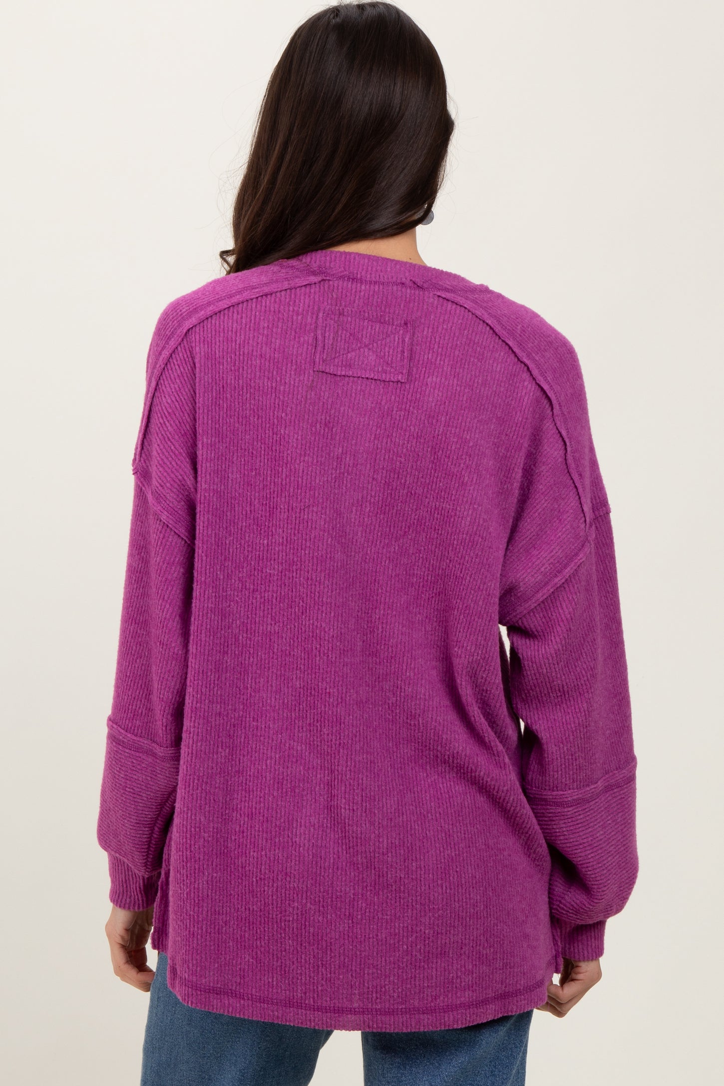 woman wearing a purple oversized corduroy sweater with dropped shoulders and long sleeves