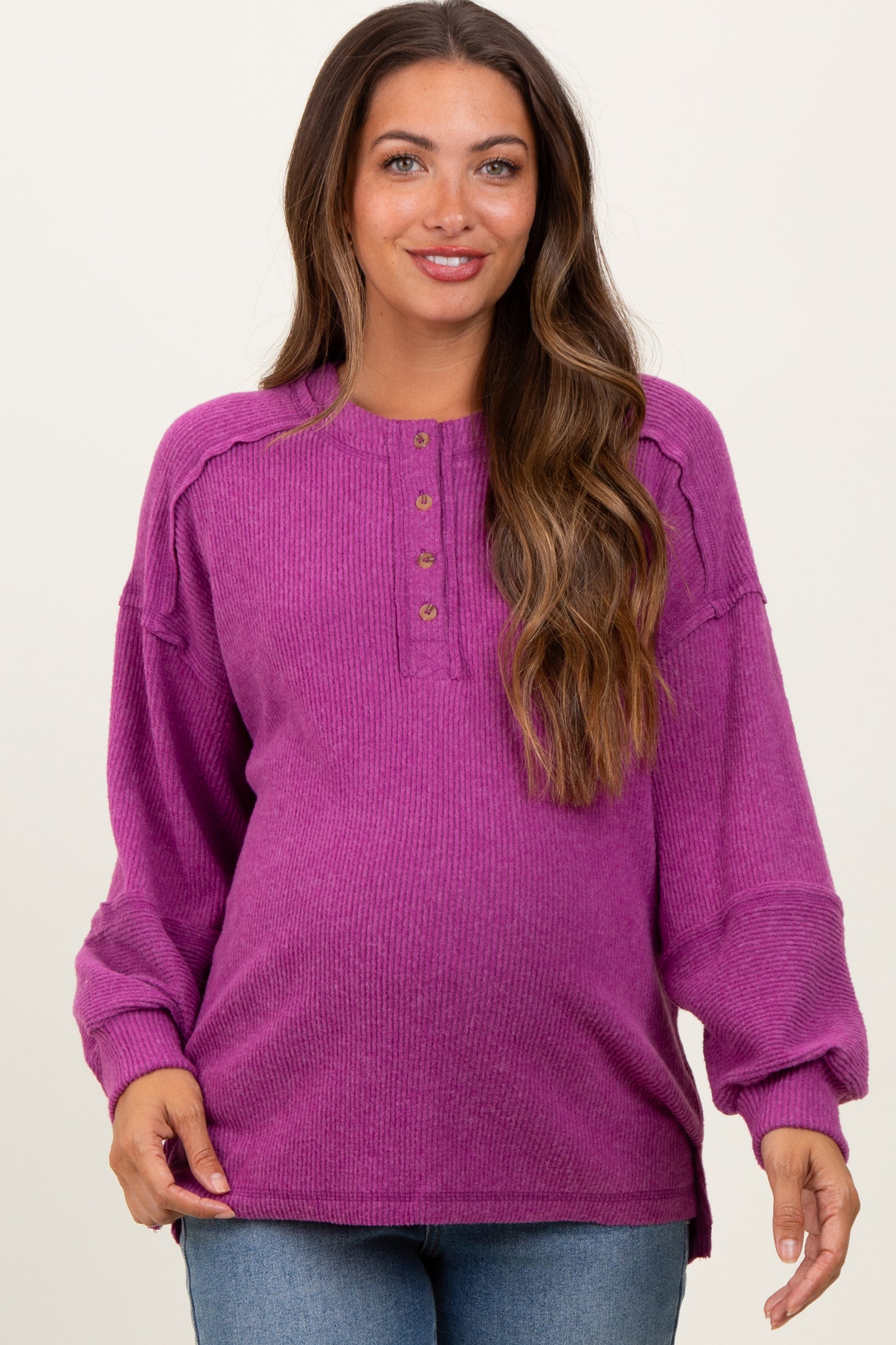 woman wearing a purple ribbed maternity top with button details and a relaxed fit, highlighting her baby bump