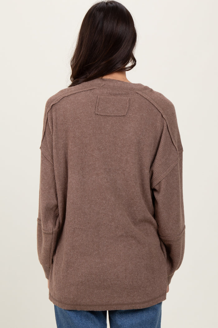 woman wearing a brown oversized ribbed sweater, showing the back view and relaxed fit