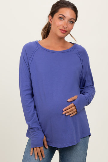 woman wearing a purple long sleeve maternity top with a relaxed fit and holding her baby bump