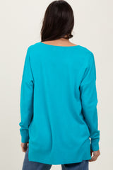 woman wearing a back view of a vibrant turquoise oversized sweater with long sleeves