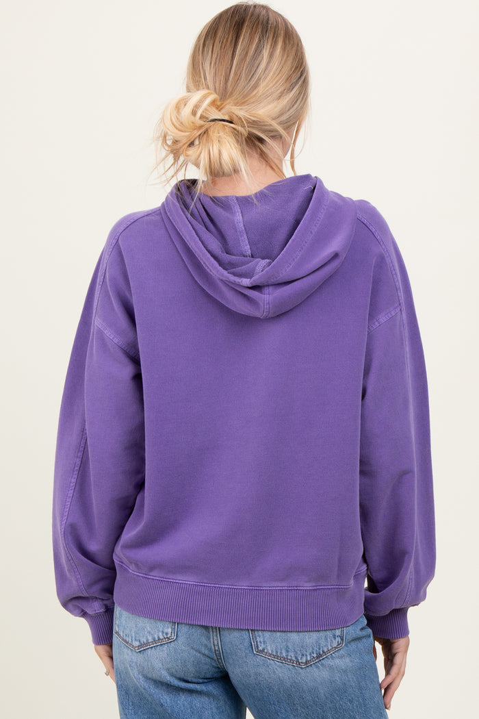 woman wearing a purple oversized hoodie with a back view and kangaroo pocket, paired with light blue jeans